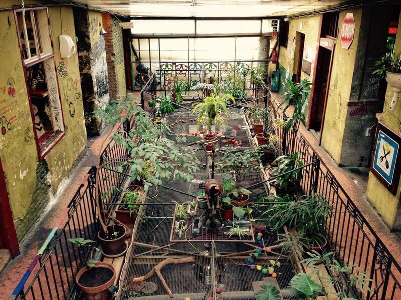 Szimpla Kert, Будапешт, Венгрия. А вот съемки артхаусного кино свободно можно проводить в Будапеште. У венгров существует интересная традиция — располагать на стенах все, что попадется под руку. Этакое своеобразное украшение жилища. И пускай подобные «декоративные элементы» не всегда смотрятся уместно, однако в большом, полуразрушенном двухэтажном сквоте Szimpla Kert они весьма гармоничны. Это здание находится в центре столицы и привлекает внимание как местных жителей, так и туристов. Изюминка Будапешта имеет необычный внешний вид и множество залов, расположенных внутри, где каждый сможет найти занятие по душе — выпить горячительных напитков, посидеть возле костра, оценить интересные инсталляции и просто потанцевать под неординарную музыку самых разных диджеев.